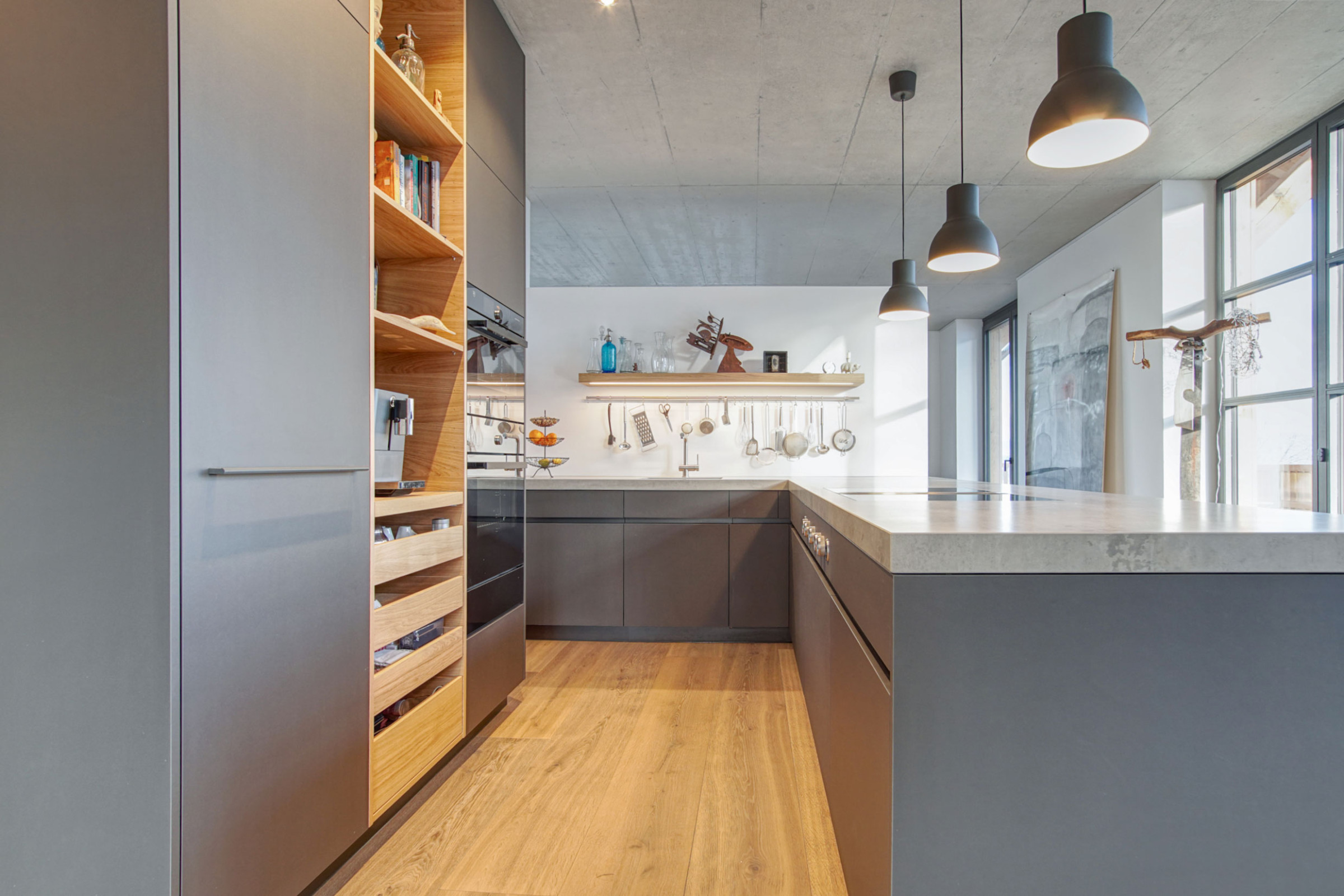 Innenansicht einer grauen K&uuml;che mit Holz
