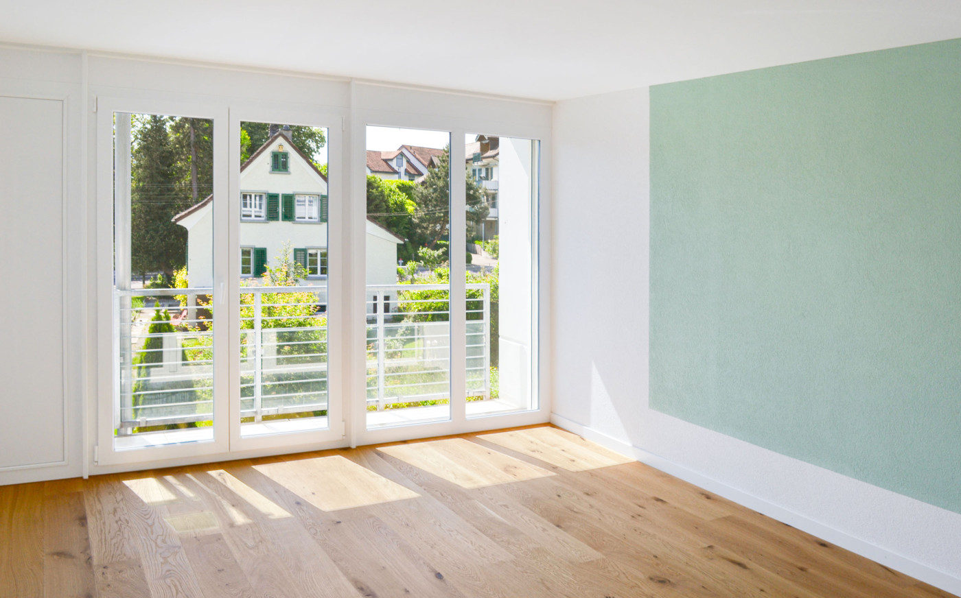 Holzboden im Raum mit Fensterfront und Wand