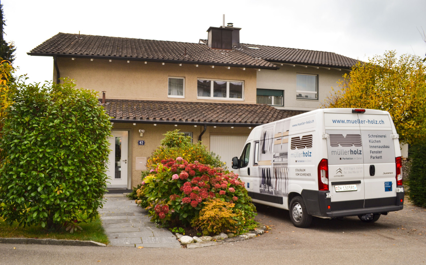 Haus mit Fenster und davor ein Transporter