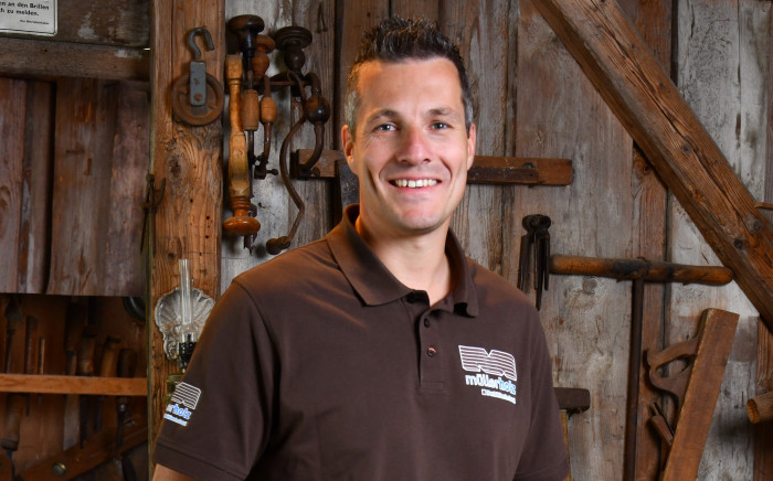 Mann in einer Werkstatt mit Holz