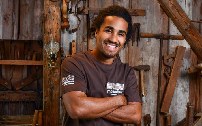 Mann in einer Werkstatt mit Holz