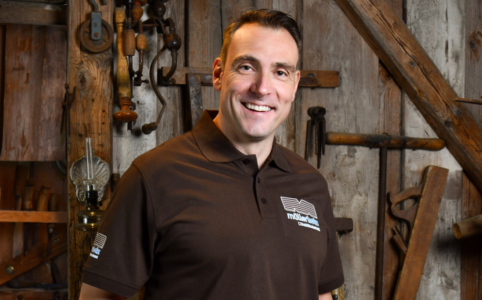 Mann in einer Werkstatt mit Holz