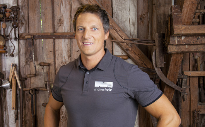 Mann in einer Werkstatt mit Holz